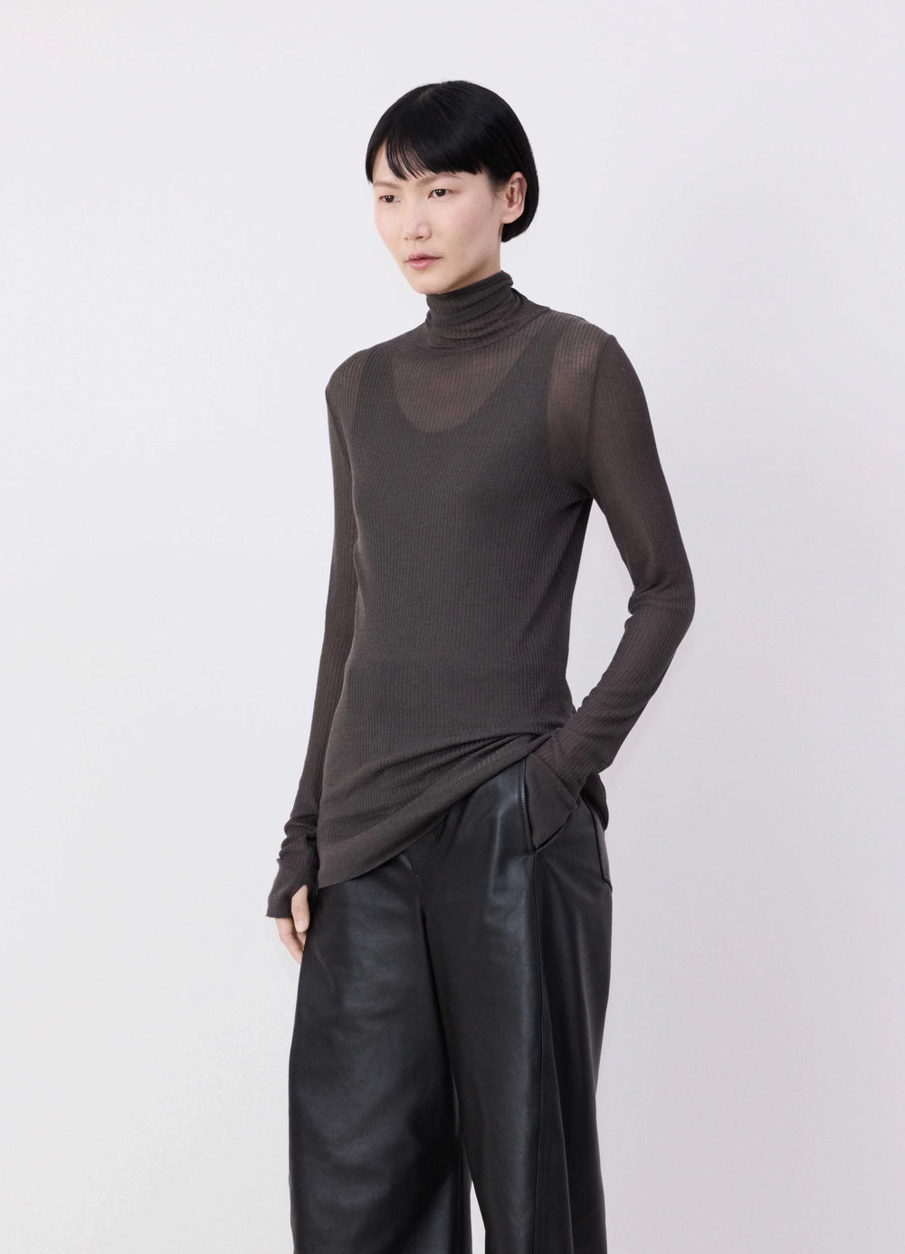 EMO Seamless High Neck Top in Dark Brown Viscose Silk, model shot, Front three-quarter view Finely ribbed see-through