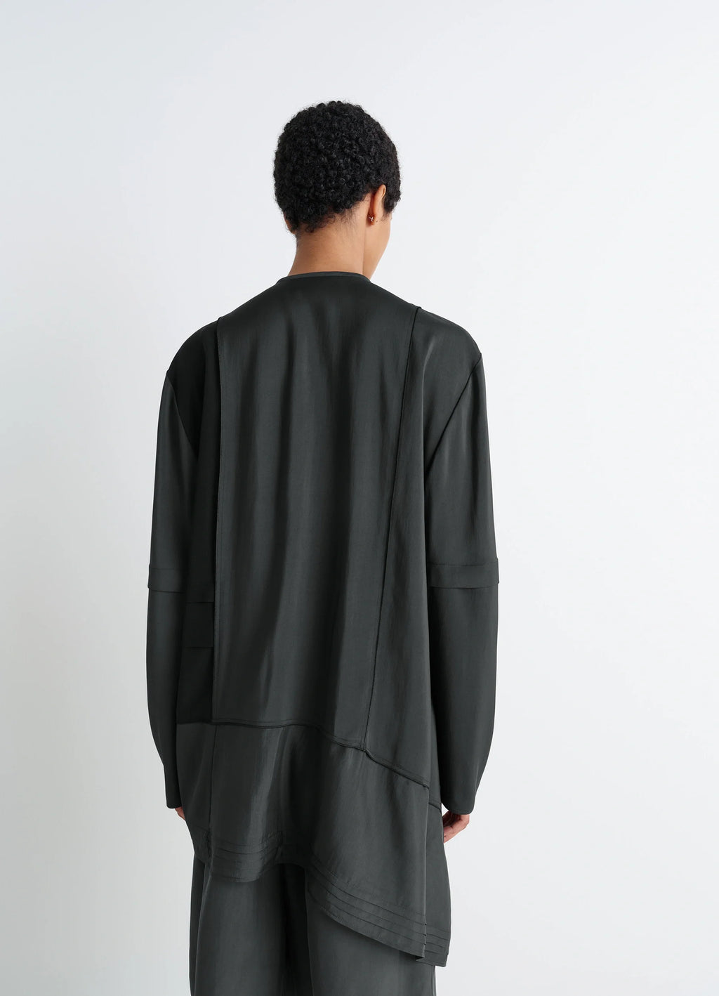 Blouse with pleats in black patchwork crepe de chine, model shot, back view full outfit flowing asymmetrical hem